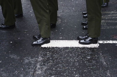 Low section of people standing on rainy day