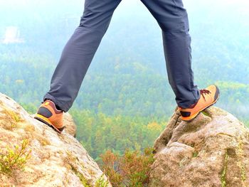 Low section of man standing on rock