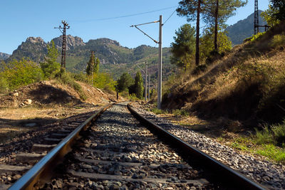 Railroad track by mountain against sky