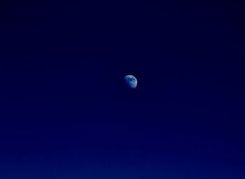 Low angle view of moon against blue sky