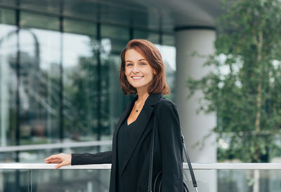 Portrait of young woman standing in city