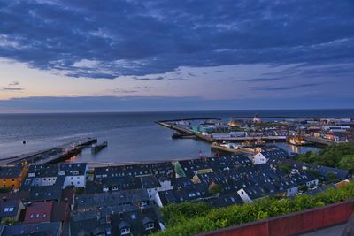 High angle view of townscape by sea against sky
