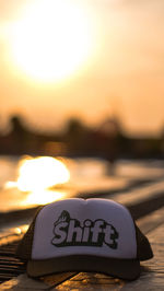 Close-up of text on orange against sky during sunset