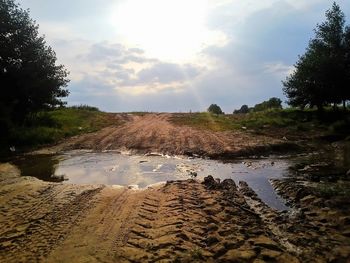 Scenic view of wet farm against sky