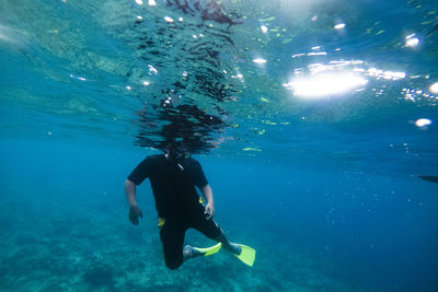 Man gesturing while snorkeling in sea 