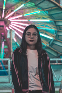 Woman standing against amusement park ride