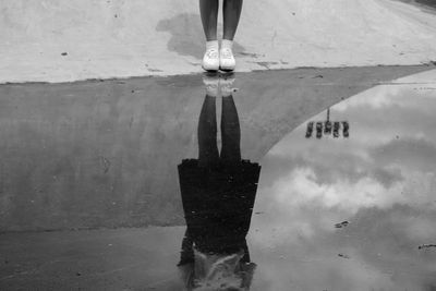 Low section of person standing on puddle