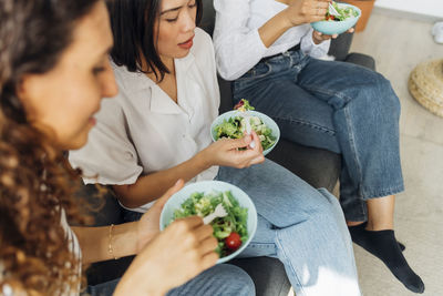 Multiracial roommates having salad for lunch at home