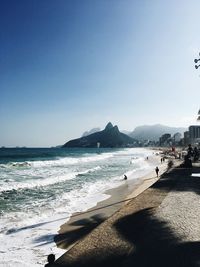 Scenic view of beach against clear blue sky