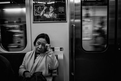 Full length of woman sitting in train