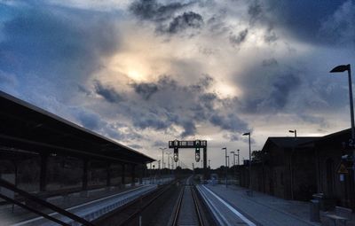 Railroad tracks against cloudy sky