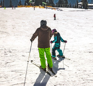 People skiing on snow covered field