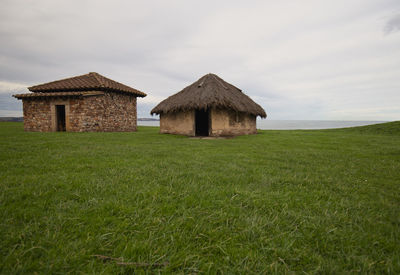 Built structure on field against sky