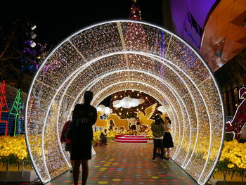 People at illuminated archway