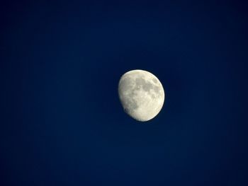 Low angle view of moon against blue sky