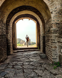 Rear view of woman walking in tunnel