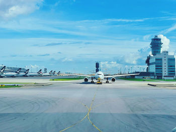 Cars on airport runway against sky