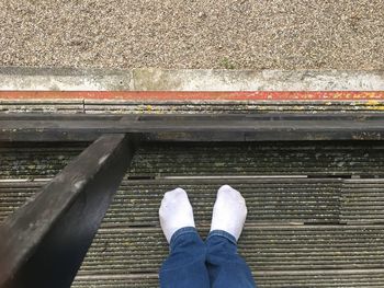 Low section of person standing on railroad track