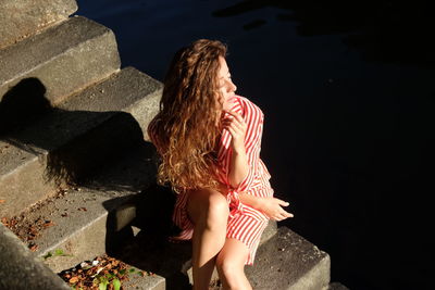 High angle view of young woman sitting on staircase