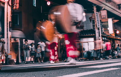 People walking on road along buildings