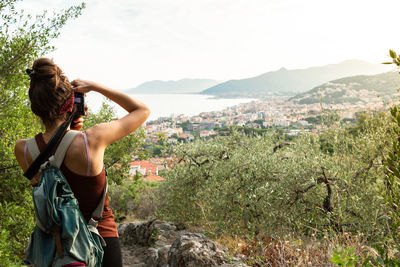 Woman standing on mountain against sky
