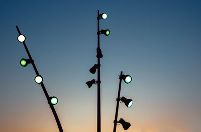 Low angle view of spotlights against clear sky during sunset