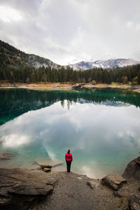 Woman standing by lake at forest