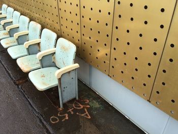 High angle view of rusty bleachers against metallic wall