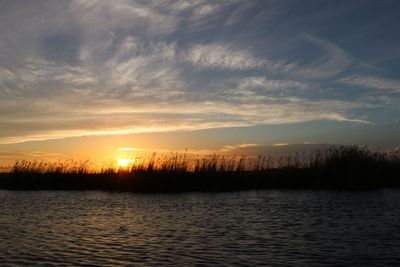 Scenic view of calm lake at sunset
