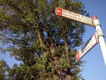 Low angle view of road sign against sky