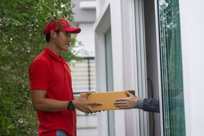 Young man delivering package to customer at doorway