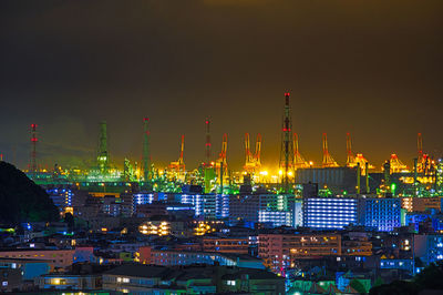 Illuminated city against sky at night