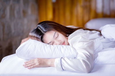 Woman sleeping on bed at home