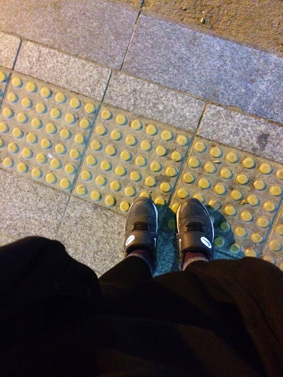 low section, person, shoe, high angle view, personal perspective, standing, street, lifestyles, human foot, footwear, shadow, yellow, men, tiled floor, cobblestone, road, directly above