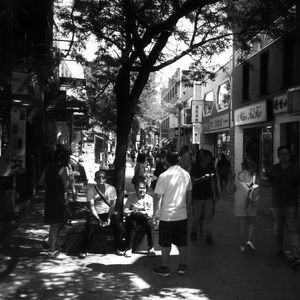 People on street amidst buildings in city