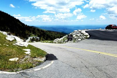 Road amidst green landscape against sky