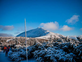 Scenic view of snowcapped mountains against blue sky