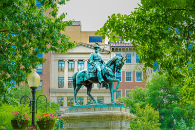 Low angle view of statue against trees