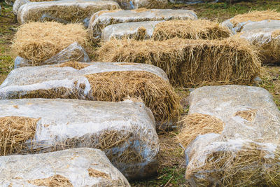 Seats and tables made from straw bales for event and party laid on lawn yard. 