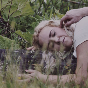 Portrait of young woman lying on field