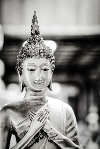 Close-up of buddha statue against building