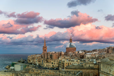 Buildings in city against cloudy sky