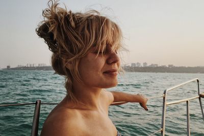 Close-up of young woman on boat in sea during sunset