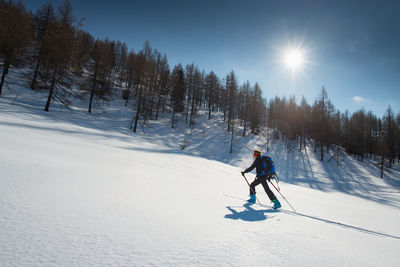 Man skiing on snow field against mountain during winter