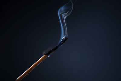 Close up of burnt matchstick against black background