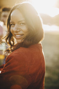 Close-up portrait of smiling young woman on sunny day