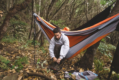 Rear view of man on hammock in forest