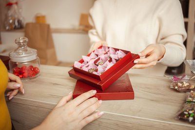 Woman chooses gift for valentine's day, beautiful tea in red packaging. 