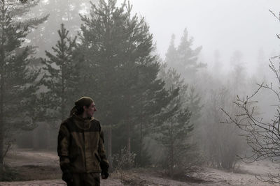 Man standing in forest during winter