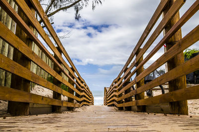 Low angle view of bridge over beach against sky